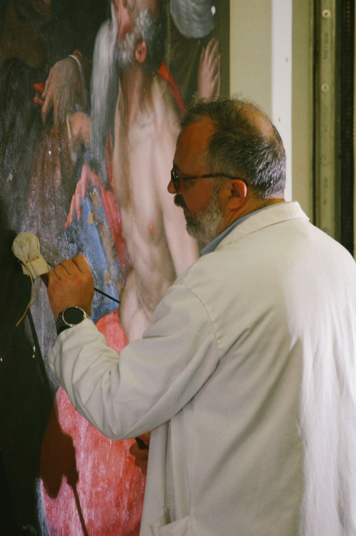 Conservator working with a brush on an old object
