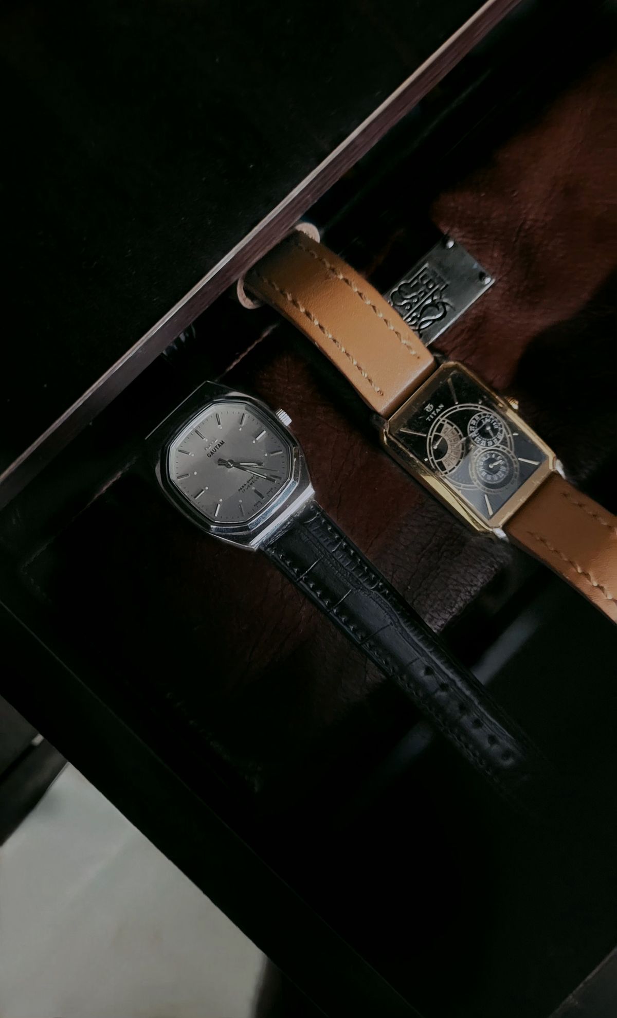 Two vintage wristwatches in a display case